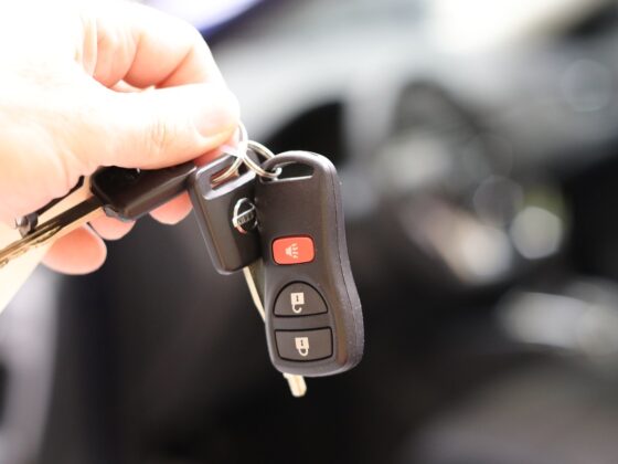 Une clé électronique de voiture tenue d'une main
