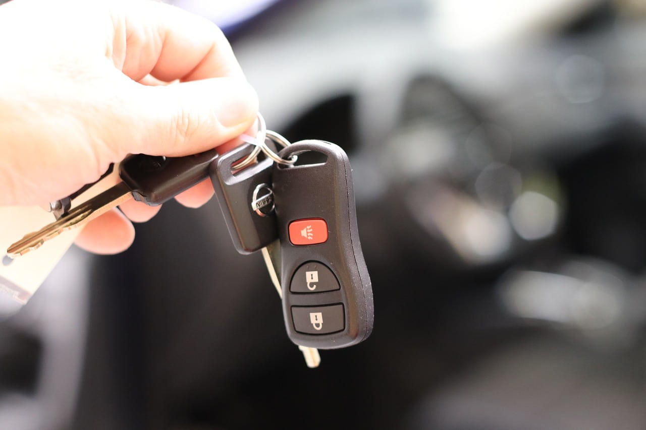 Une clé électronique de voiture tenue d'une main