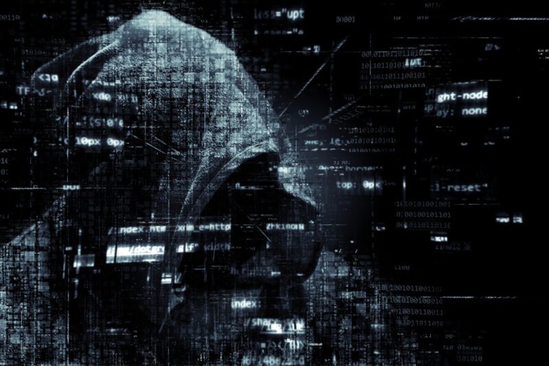 un hacker sur fond noir avec du code incrusté
