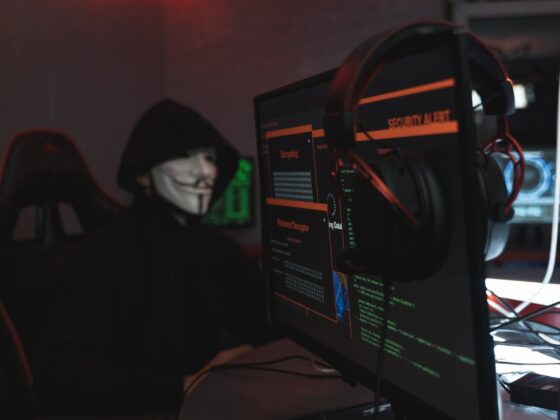 person in black hoodie hacking a computer system