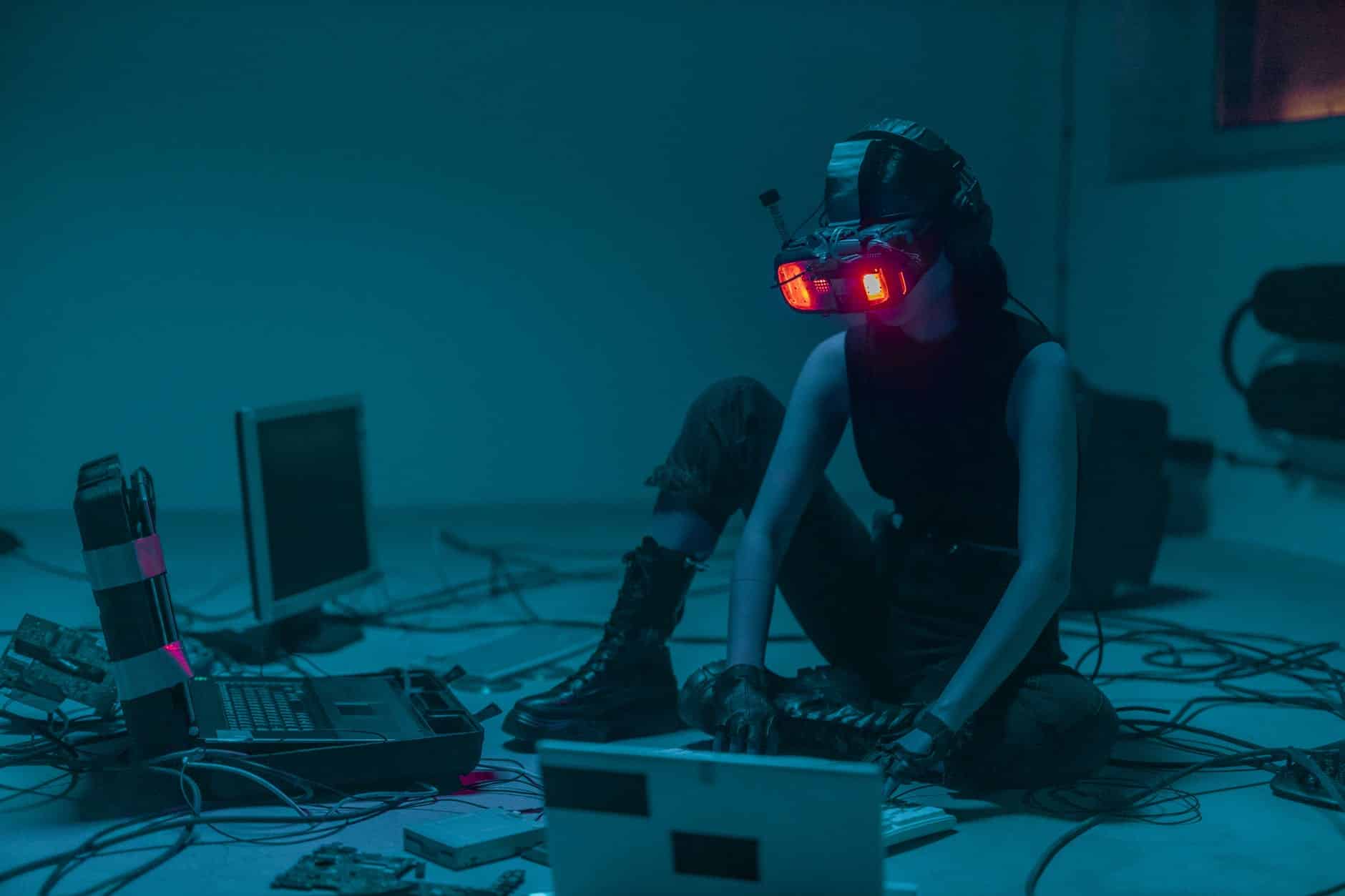 une personne assise sur le sol avec des lunettes vr utilisant un ordinateur