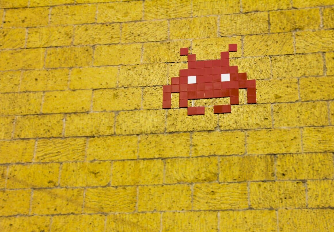 Un virus rouge en mosaïque sur un mur de brique jaune