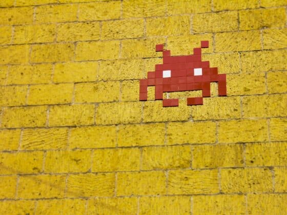 Un virus rouge en mosaïque sur un mur de brique jaune