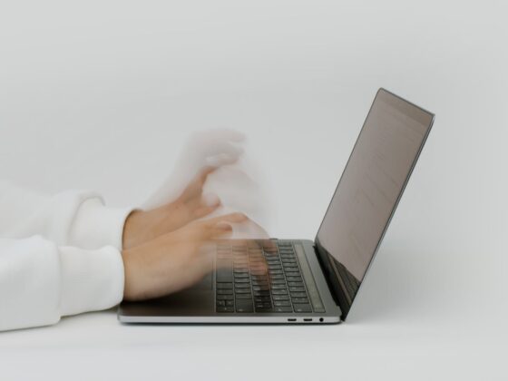hands typing on a laptop keyboard