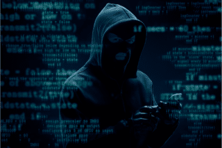 Un cybercriminel à capuche au milieu de code en surimpression