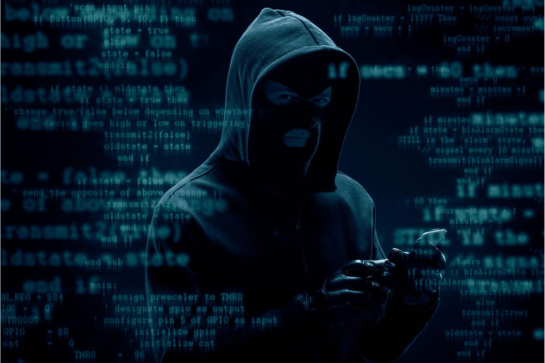 Un cybercriminel à capuche au milieu de code en surimpression