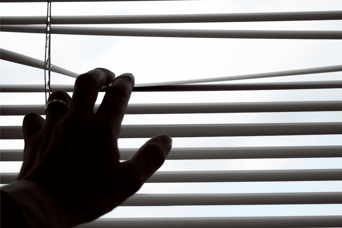 un main qui ouvre des lamelle de store