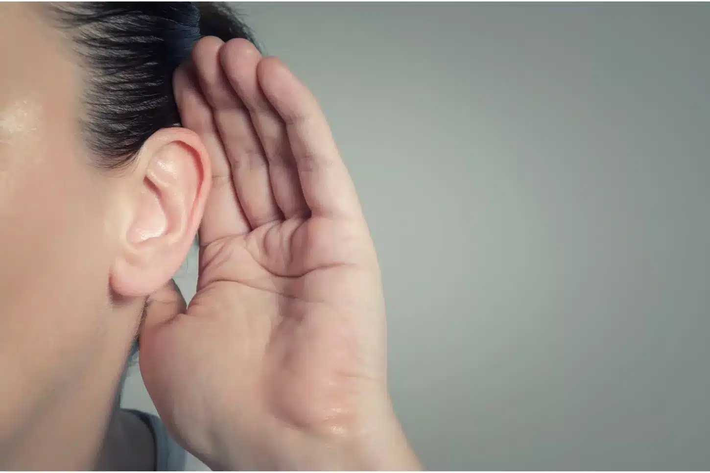 une main derrière une oreille pour mieux écouter