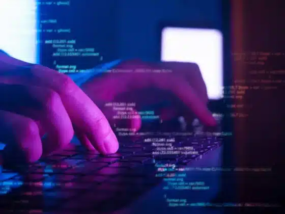 Du code avec en surimpression une image de main sur un clavier