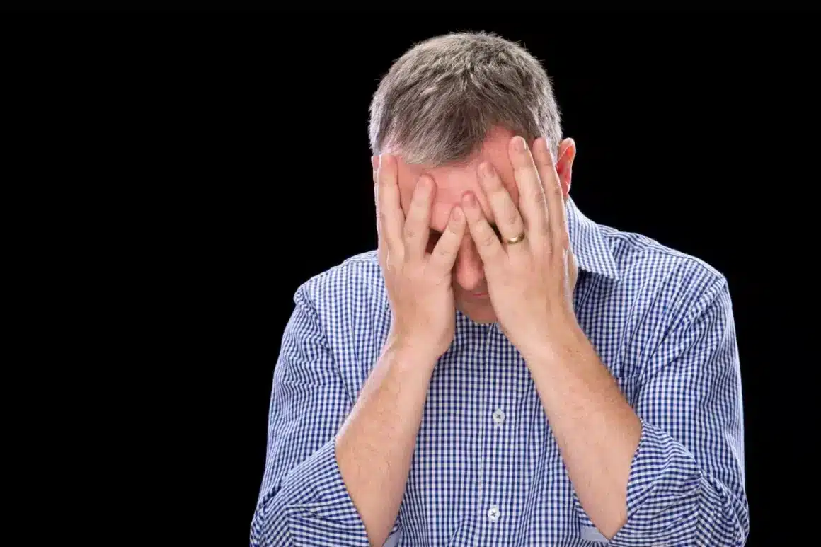 Une personne désespérée qui se tient sa tête entre ses mains