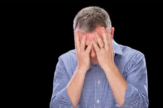 Une personne désespérée qui se tient sa tête entre ses mains