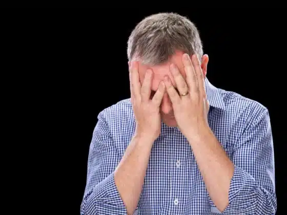 Une personne désespérée qui se tient sa tête entre ses mains