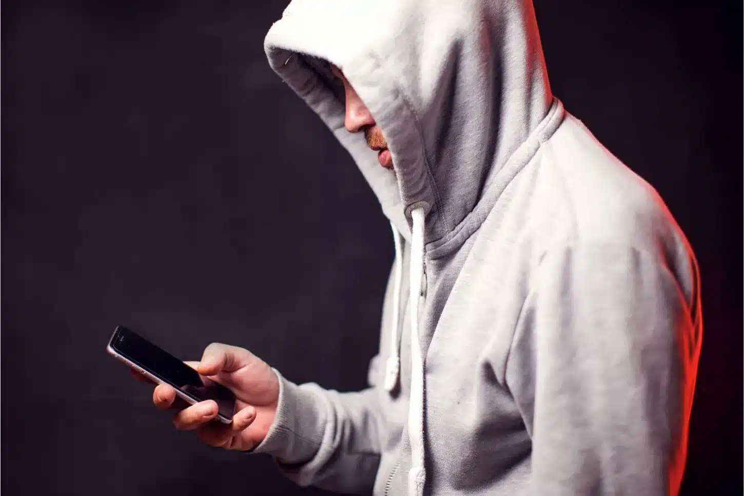 une personne avec un sweat à capuche avec un mobile