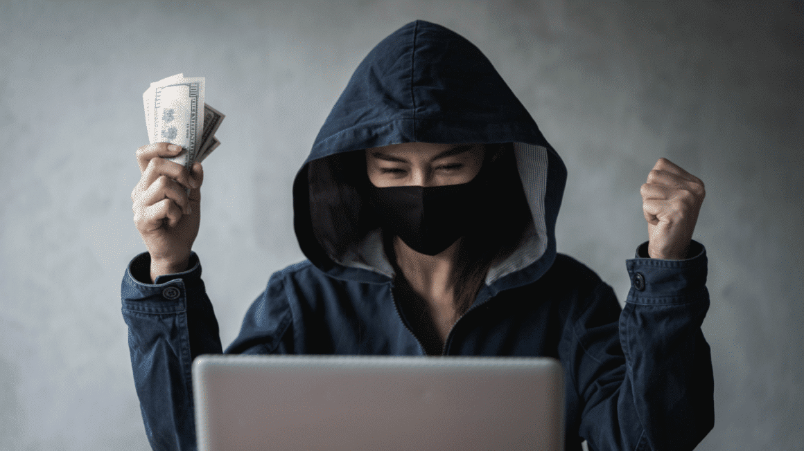 Un hacker avec de largent dans une main