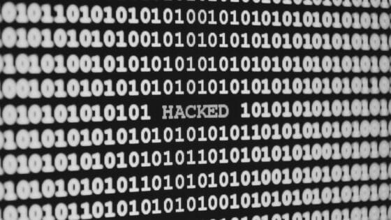 Un fond de 0 et 1 avec la mention hacked pour pirate