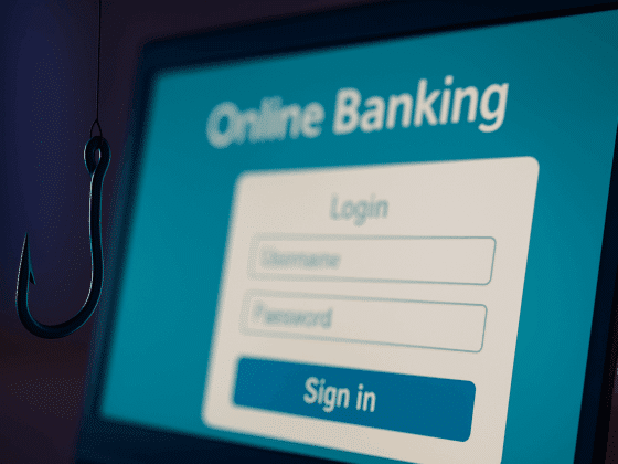 Un hameçon suspendu devant un écran d’ordinateur affichant une page de connexion à une banque en ligne. L’image illustre une tentative de phishing en ligne dans un contexte sobre et moderne, avec un contraste visuel fort pour attirer l’attention sur le risque.