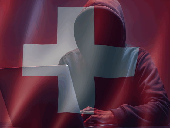Silhouette encapuchonnée devant un ordinateur portable, symbolisant une cybermenace, sur fond de drapeau suisse translucide et ambiance sombre — évoquant les enjeux de cybersécurité en Suisse