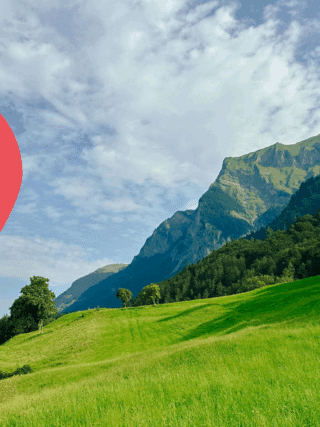 Vue panoramique d’un paysage verdoyant dans les Alpes suisses, avec un pic montagneux en arrière-plan et une icône de géolocalisation rouge au premier plan — illustration d’un test de géolocalisation assistée par intelligence artificielle.