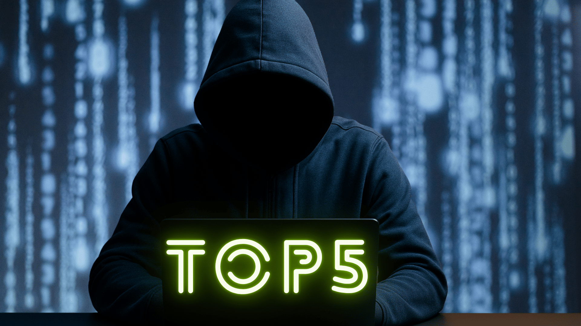 Image réaliste d'une personne encapuchonnée, assise devant un ordinateur portable dans un environnement sombre, illustrant les menaces liées au cybercrime, aux attaques informatiques et à la cybersécurité.