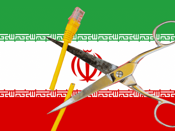 Une paire de ciseaux coupant un câble Ethernet jaune sur fond du drapeau iranien, symbolisant la coupure d’Internet décidée par l’Iran face à des cyberattaques.