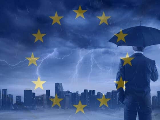 Un homme en costume vu de dos tenant un parapluie, face à une ville sous un orage violent. En surimpression, les étoiles du drapeau européen symbolisent la protection et la coordination de l’Union européenne face aux crises. L’ambiance visuelle évoque la cybersécurité et la résilience en contexte de menace.
