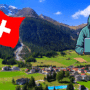 Vue d’un village alpin suisse avec un drapeau suisse et une silhouette de hacker en surimpression, illustrant les risques de cybersécurité auxquels sont confrontées les communes suisses.