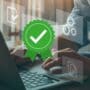 Personne utilisant un ordinateur portable avec des icônes virtuelles illustrant la validation de la qualité, la conformité et les paramètres techniques, mise en avant d’un badge vert avec une coche blanche symbolisant la certification.