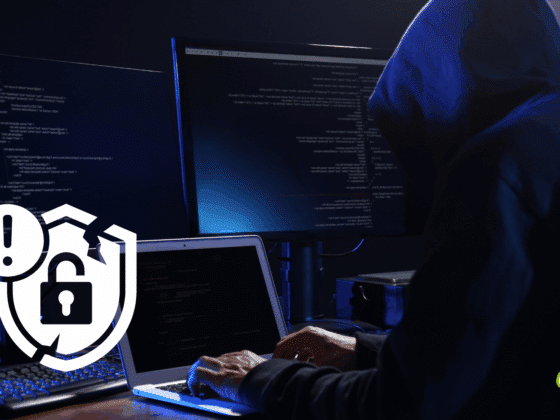 Personne portant un sweat à capuche devant plusieurs écrans affichant du code, représentant une cyberattaque en cours, avec une icône de sécurité cassée en surimpression.
