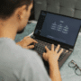 Utilisateur travaillant sur un ordinateur portable affichant l’interface ChatGPT, illustrant les risques de sécurité et détournements possibles des IA.
