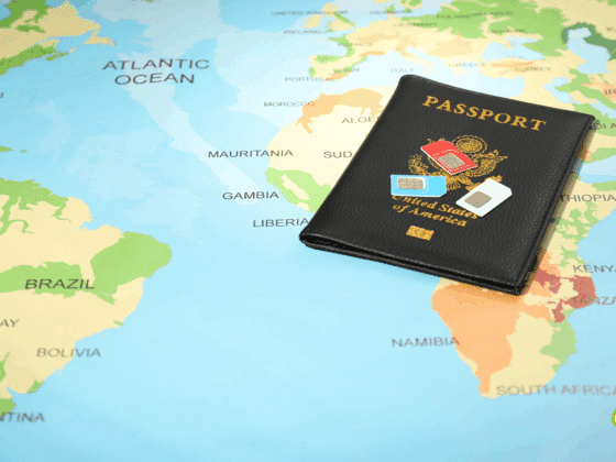 Passeport des États-Unis posé sur une carte du monde, accompagné de plusieurs cartes SIM internationales, illustrant la préparation à un voyage à l'étranger.