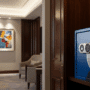 Un coffre-fort Securam de couleur sombre est intégré de manière élégante dans le placard en bois d'une chambre d'hôtel à l'ambiance feutrée et moderne. La lumière douce met en valeur le design du coffre-fort et l'atmosphère accueillante de la pièce, évoquant la sécurité et le confort