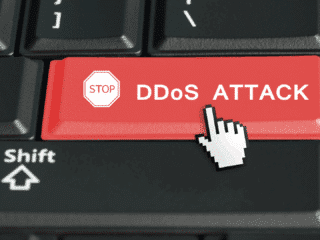 Touche rouge d’un clavier d’ordinateur portant l’inscription « STOP DDoS ATTACK » avec un curseur en forme de main, symbolisant l’interruption d’une attaque par déni de service distribué (DDoS)