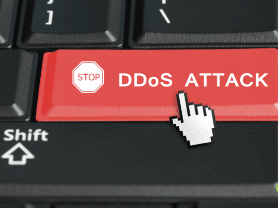 Touche rouge d’un clavier d’ordinateur portant l’inscription « STOP DDoS ATTACK » avec un curseur en forme de main, symbolisant l’interruption d’une attaque par déni de service distribué (DDoS)