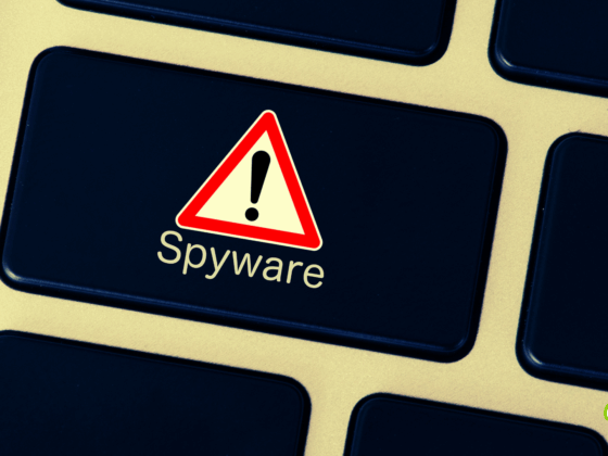 Touche de clavier d’ordinateur affichant un symbole d’avertissement rouge avec un point d’exclamation et le mot « Spyware », signalant un risque de logiciel espion.