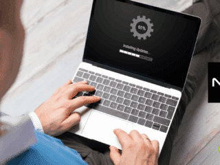 Vue en plongée d’un homme utilisant un ordinateur portable affichant une mise à jour en cours (65 %), illustrant un processus de mise à jour système conforme aux recommandations de cybersécurité du NIST, avec les logos NIST et dcod visibles à l’écran