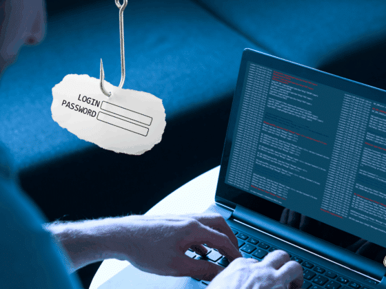 Un développeur tapant sur un ordinateur portable avec un écran affichant du code, tandis qu’un hameçon suspend un papier portant les champs « Login » et « Password », illustrant une attaque de phishing informatique.