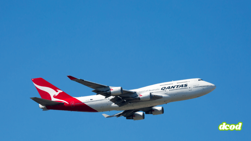 Avion de ligne Boeing 747 de la compagnie Qantas, reconnaissable à sa queue rouge avec un kangourou blanc, en vol sous un ciel dégagé.