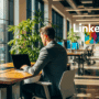 Un professionnel travaillant sur un ordinateur portable dans un bureau moderne et lumineux et incluant un logo Linkedin