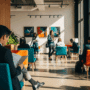 Photographie hyper-réaliste d'une personne patientant dans le hall moderne et lumineux d'une agence de l'emploi