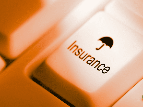 Gros plan sur une touche de clavier blanche avec l’icône d’un parapluie et le mot « Insurance », représentant l’accès aux services d’assurance en ligne.