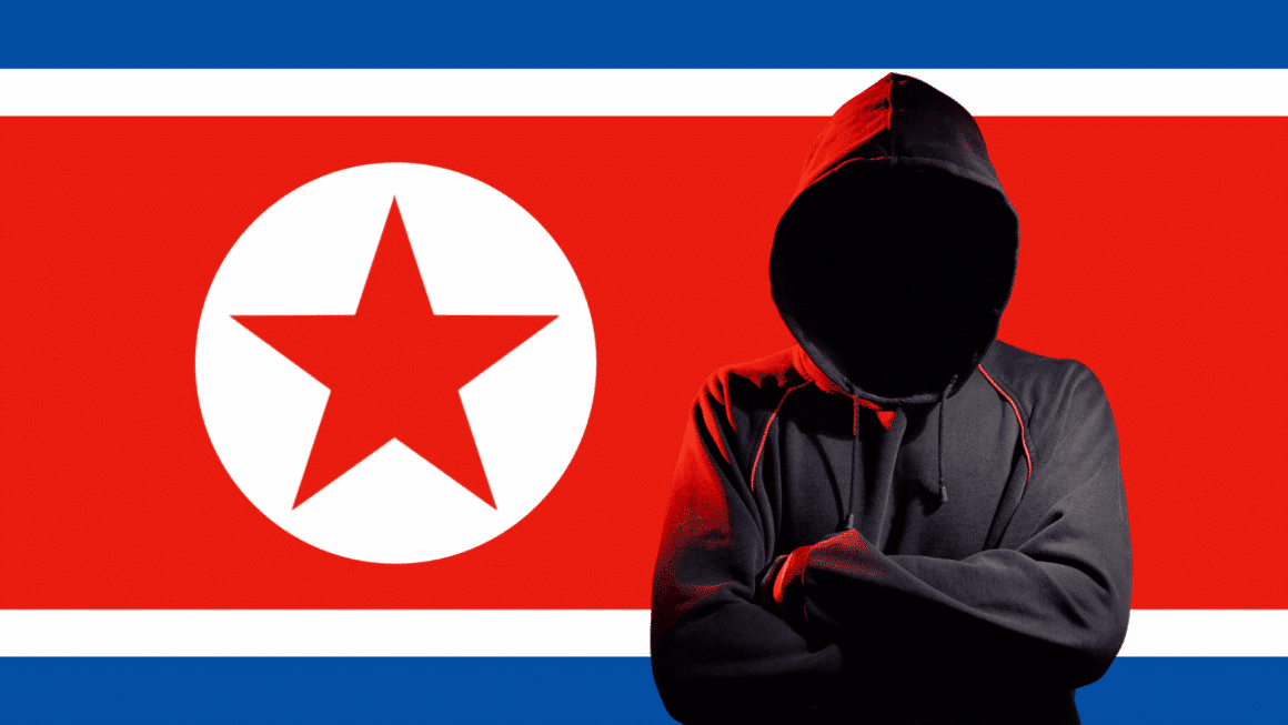 Personne en sweat à capuche noire, visage masqué par l’ombre, symbolisant un hacker, positionnée devant le drapeau de la Corée du Nord, représentant la cybercriminalité ou les activités de piratage informatique attribuées au pays.