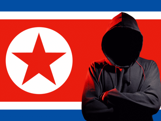 Personne en sweat à capuche noire, visage masqué par l’ombre, symbolisant un hacker, positionnée devant le drapeau de la Corée du Nord, représentant la cybercriminalité ou les activités de piratage informatique attribuées au pays.