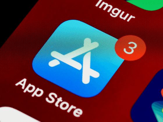 Gros plan de l'icône de l'App Store sur l'écran d'un smartphone, affichant une notification rouge avec le chiffre 3, indiquant des mises à jour d'applications disponibles.