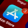 Gros plan de l'icône de l'App Store sur l'écran d'un smartphone, affichant une notification rouge avec le chiffre 3, indiquant des mises à jour d'applications disponibles.