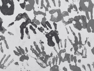 Mur recouvert de multiples empreintes de mains d'enfants peintes en différentes nuances de gris, créant un motif artistique abstrait. Logo « dcod » visible en bas à droite.