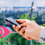 Personne utilisant un smartphone avec des bulles de messages et une icône d’œil rose, symbolisant la surveillance des échanges numériques et les enjeux de confidentialité sur mobile.