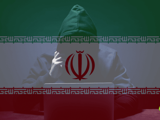 Hacker anonyme en sweat à capuche, assis devant un ordinateur portable, sur fond du drapeau iranien semi-transparent, symbolisant une cyberattaque ou une menace informatique liée à l’Iran.