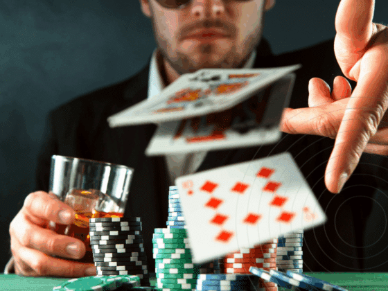Homme en costume jetant ses cartes lors d'une partie de poker, avec des piles de jetons colorés et un verre de whisky à la main, illustrant l’intensité et le suspense du jeu.