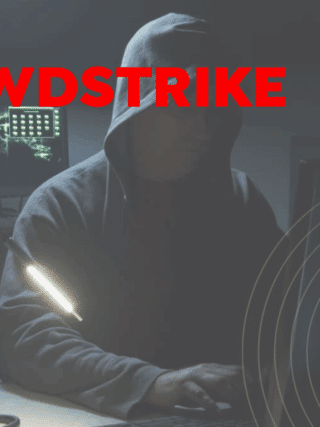 Une personne encapuchonnée devant plusieurs écrans dans une pièce sombre, symbolisant une compromission interne liée au partage de données sensibles.