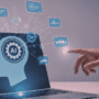 Main humaine pointant vers un écran d'ordinateur portable affichant une silhouette avec une icône "AI", entourée de graphiques de données connectés en réseau, illustrant l’intelligence artificielle et l’analyse de données.